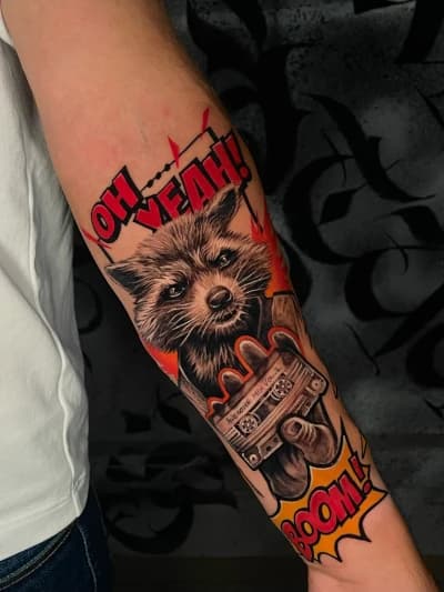 Neo-traditionele Rocket Raccoon tattoo met cassettebandje en tekstballonnen.