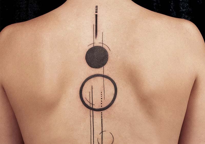 Geometrische ruggengraat tattoo met cirkels en lijnen.
