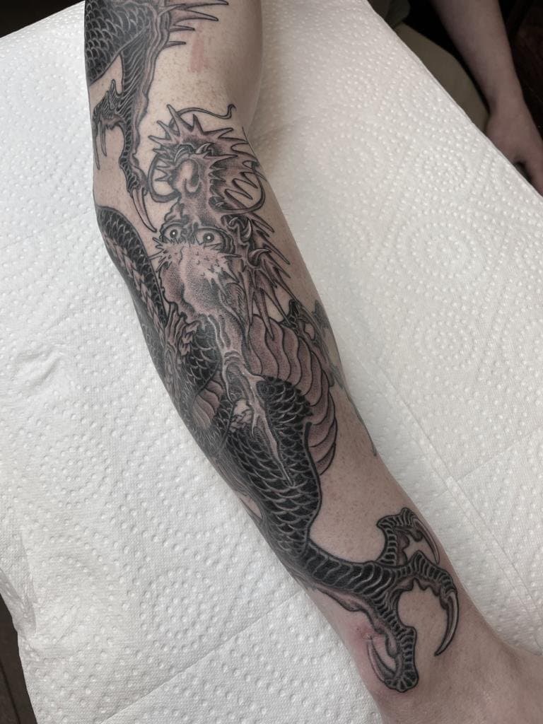 Grote zwart-witte Japanse draak op het onderbeen.