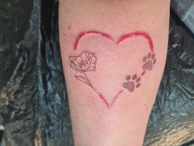 Rood hart met fineline bloem en pootafdrukken op onderbeen.