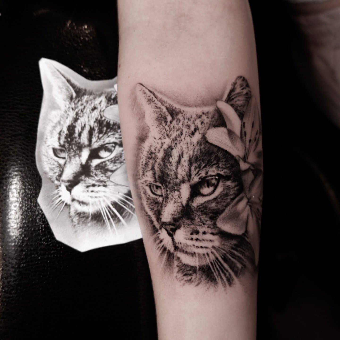 Realistische kattenkop met een lelie op de onderarm.