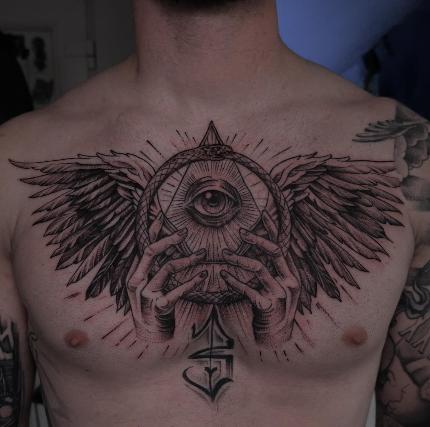 Groot borststuk met alziend oog, handen en vleugels in blackwork stijl.