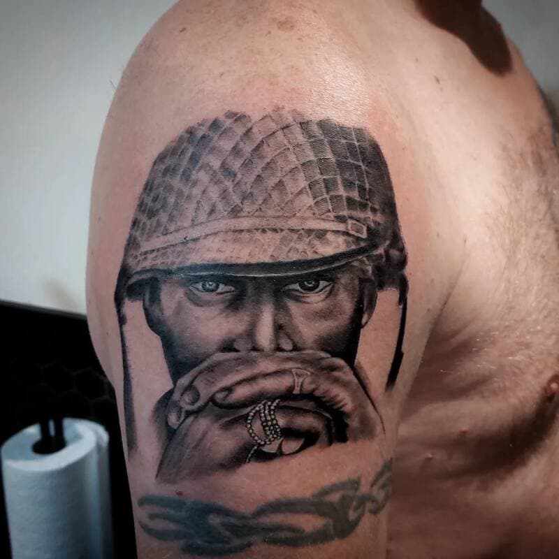 Realistisch portret van soldaat met helm en handen voor gezicht op bovenarm.