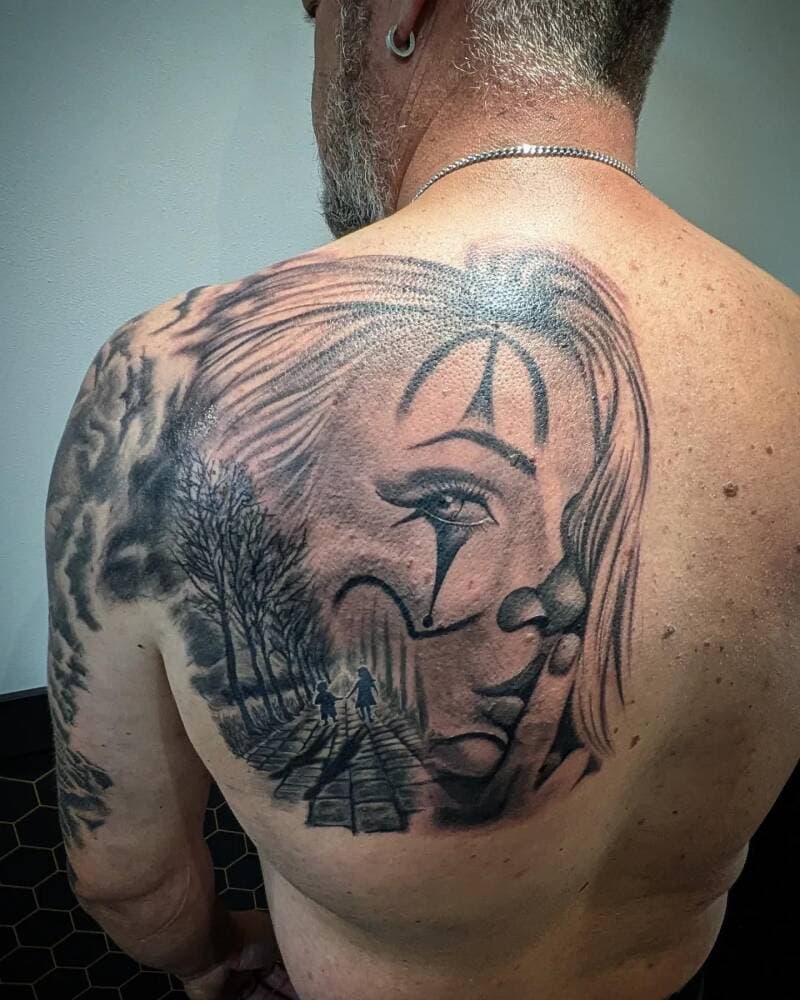 Realistisch portret van vrouw met clownsmake-up en bomenlaan op schouderblad.