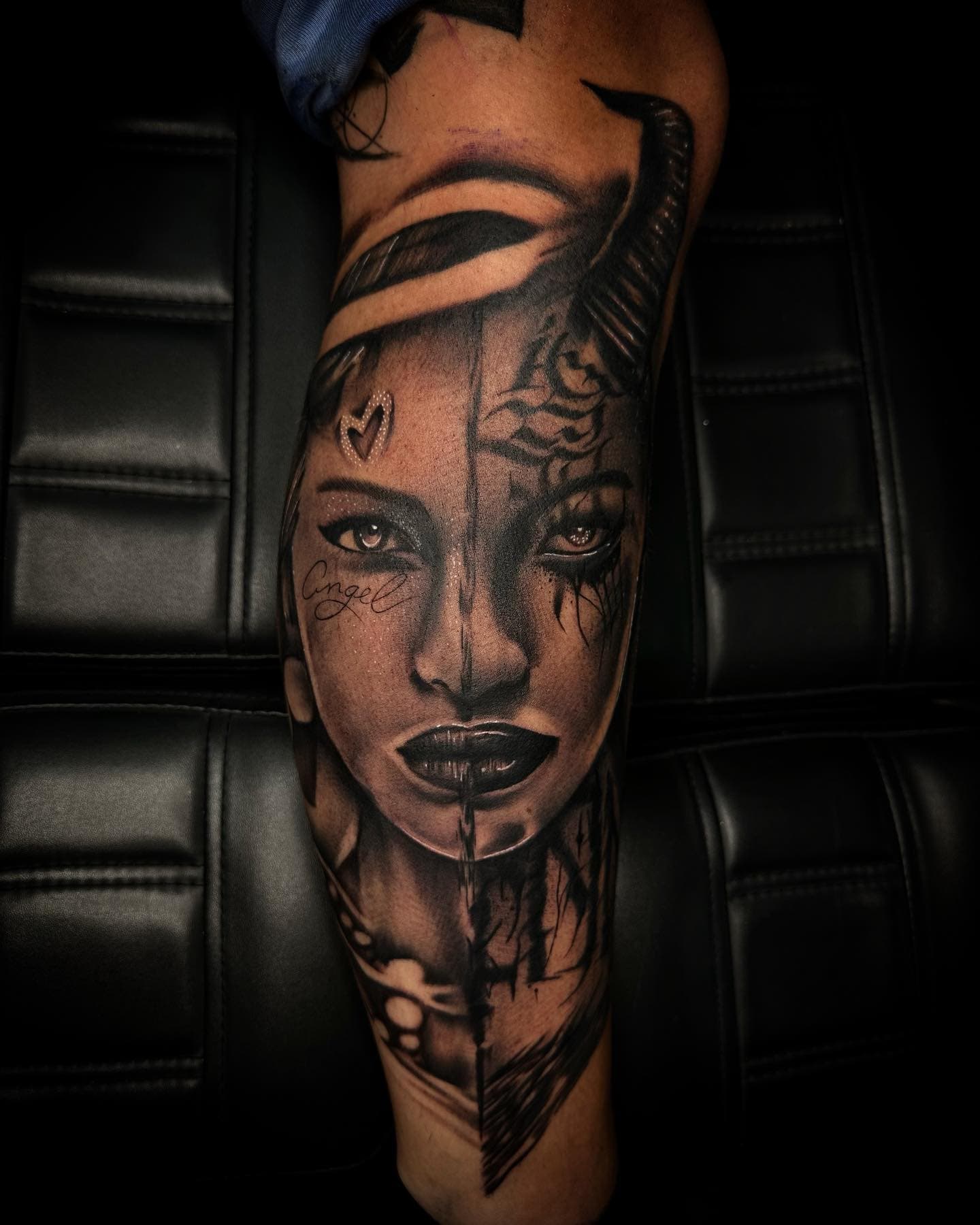 Groot portret tattoo op onderbeen, half engel half duivel gezicht.