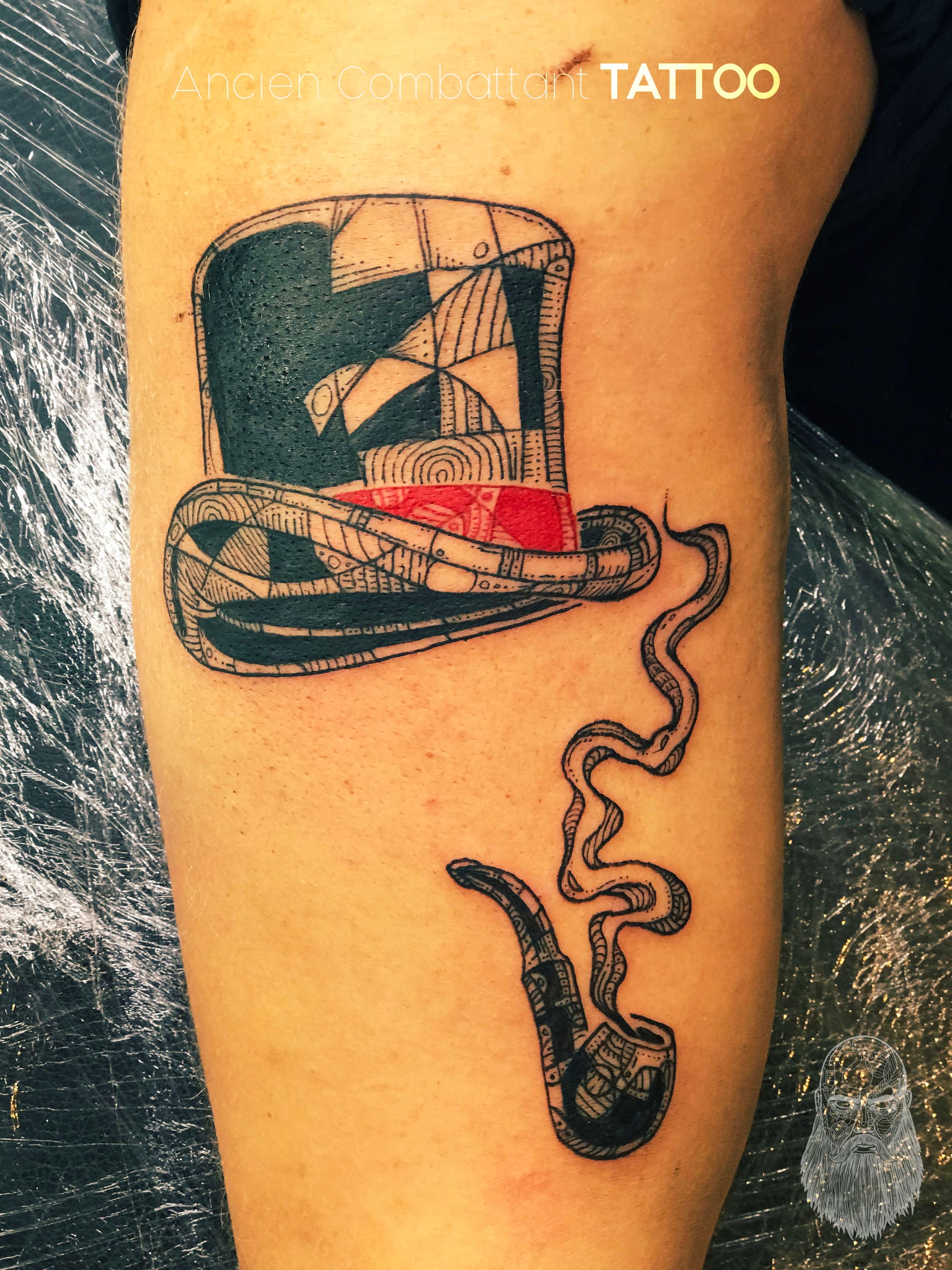 Illustratieve tattoo van een hoge hoed en een rokende pijp met patronen.