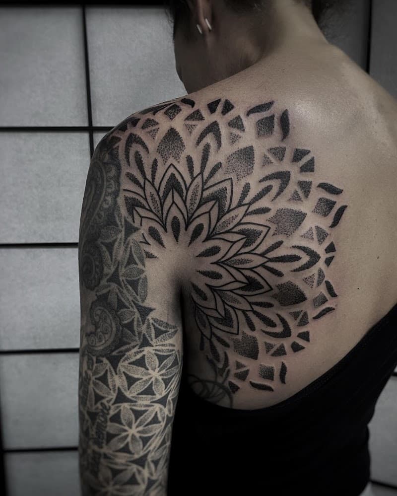 Grote dotwork mandala tattoo op schouder en rug.