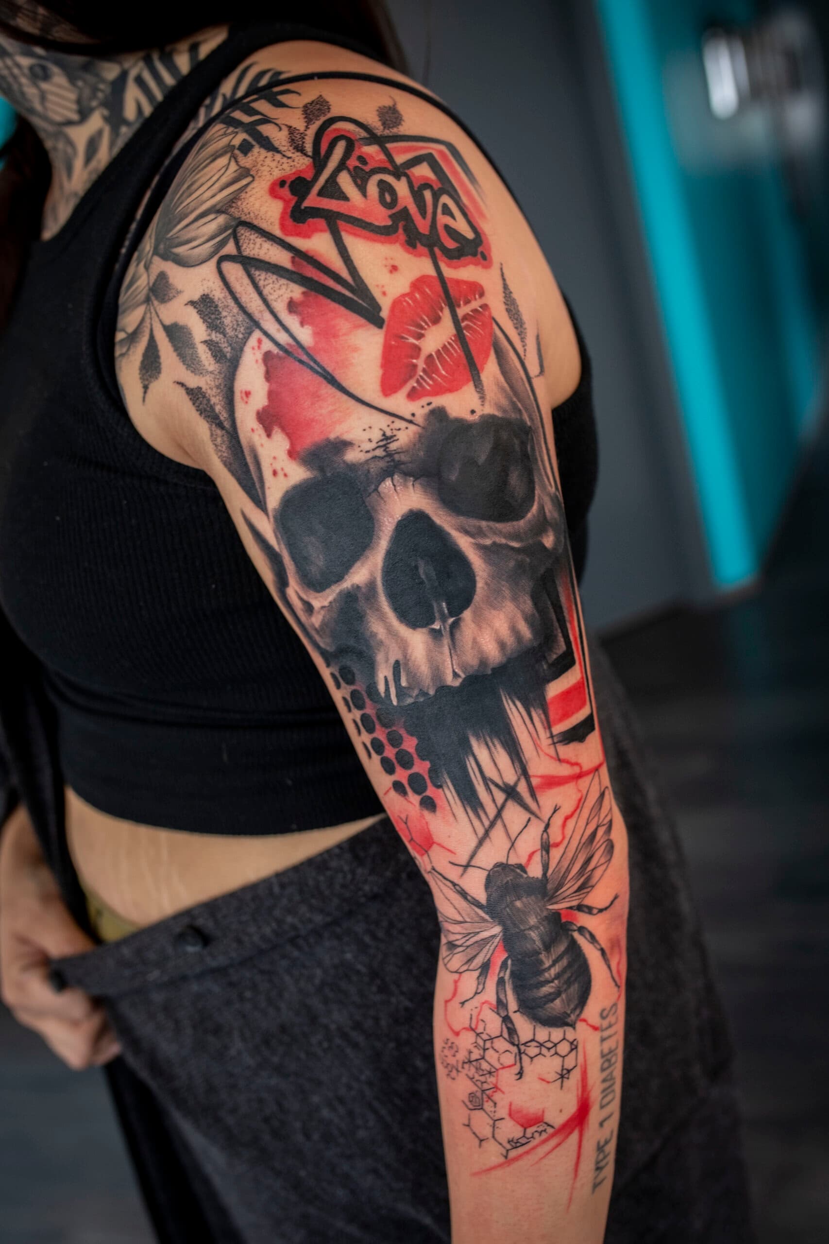 Trash polka schedel, bij en tekst op bovenarm en onderarm.