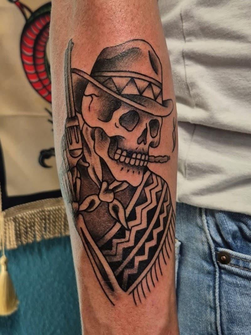 Traditionele tattoo van een skelet cowboy met hoed, sigaar en geweer op de onderarm.