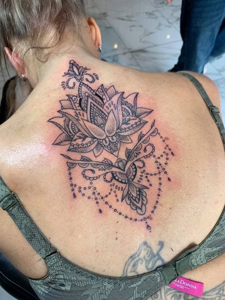 Grote lotusbloem met sierlijke details en hangende kettingen op de bovenrug.