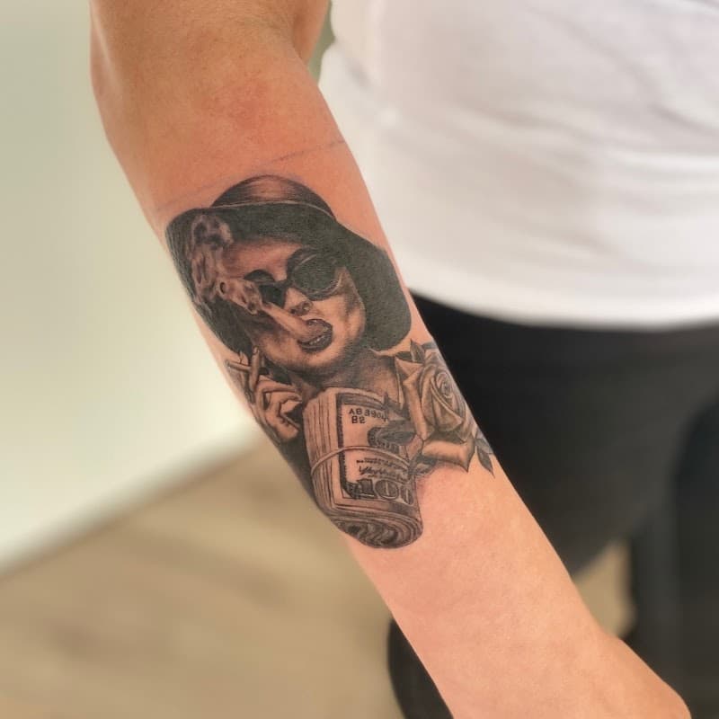 Realistische tattoo van rokende vrouw met geld en roos op onderarm.