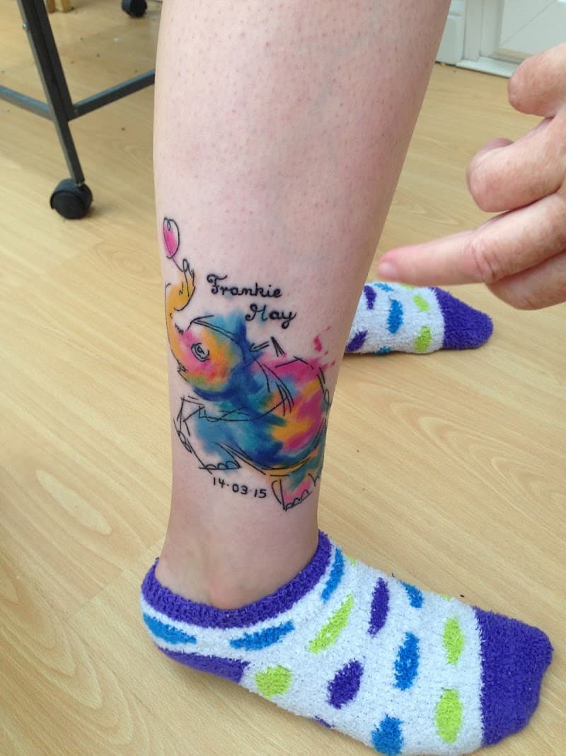 Kleurrijke olifant met naam 'Frankie May' en datum op enkel.