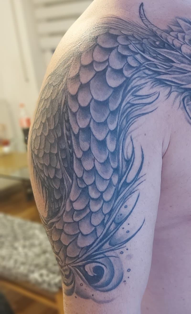 Gedetailleerde zwart-wit drakenschubben op bovenarm en schouder.