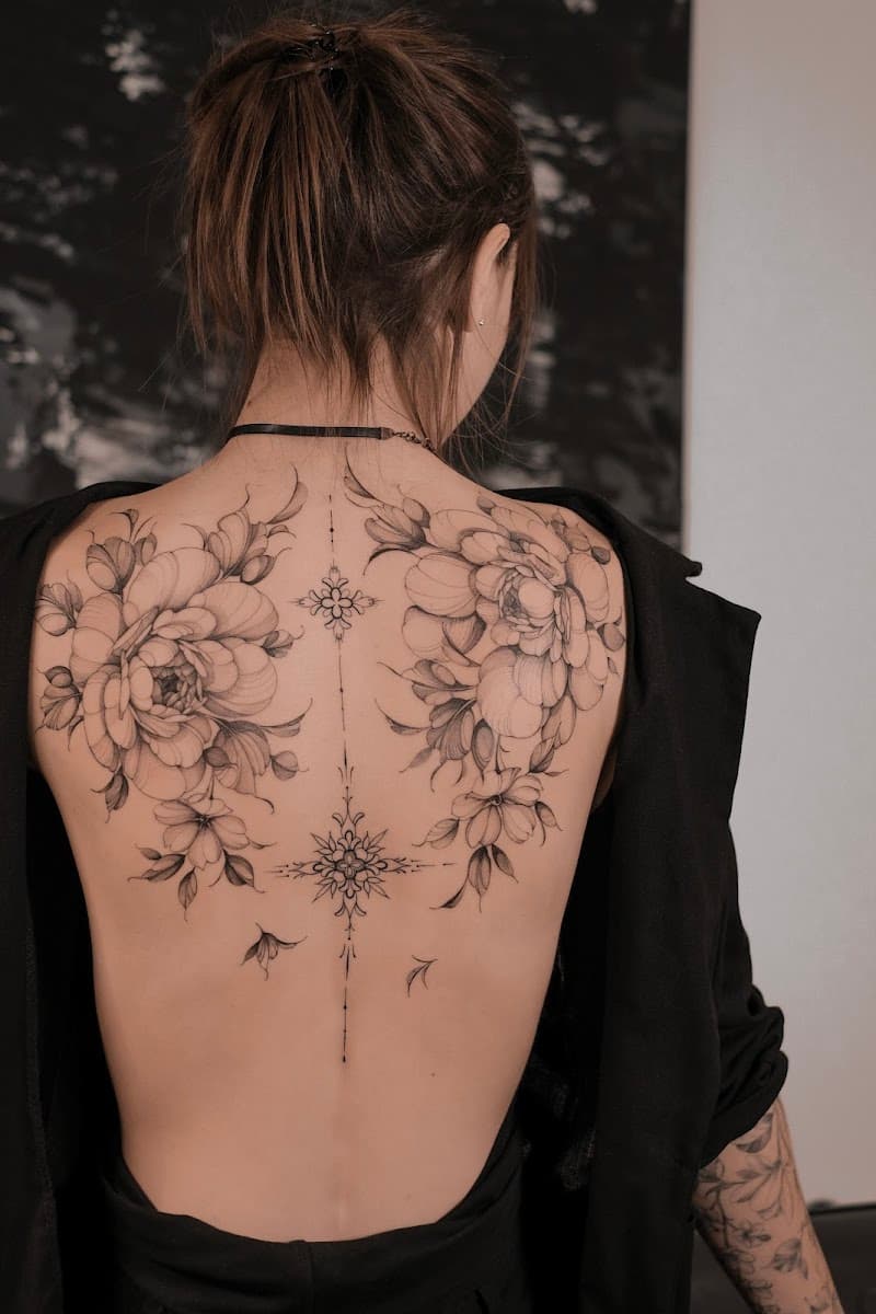 Grote fineline bloemen en ornamenten tattoo op de volledige rug.
