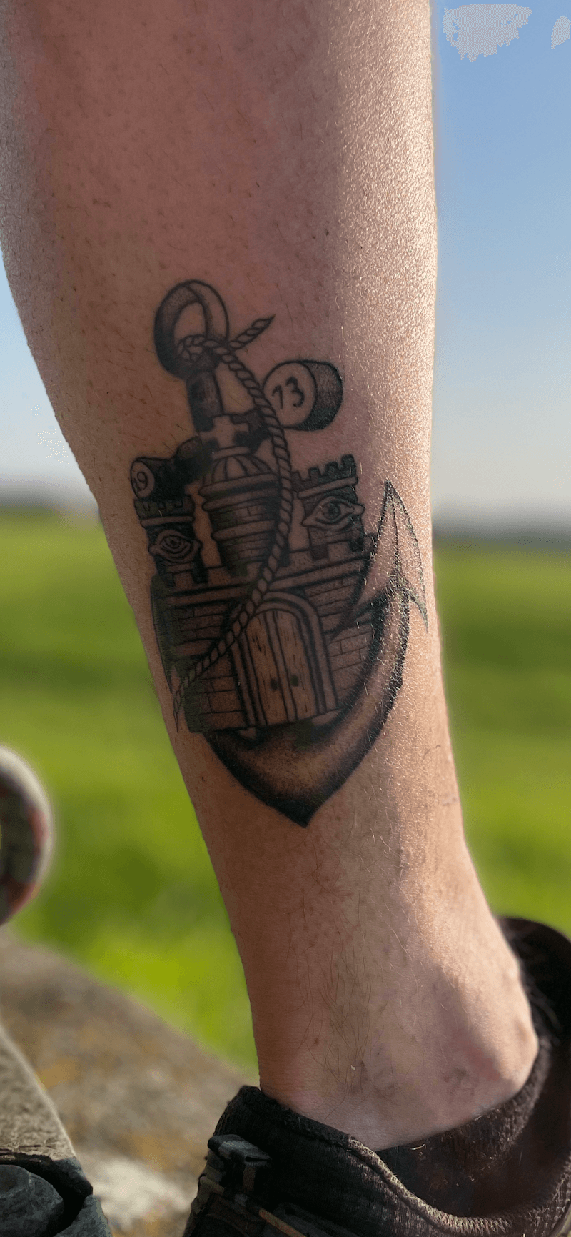 Blackwork tattoo van een anker met een kasteel, touw en het getal 13.