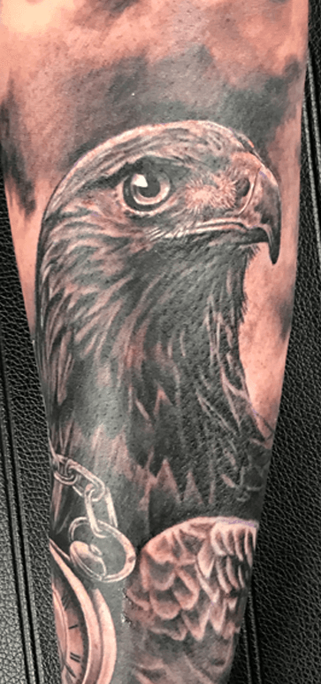 Realistische adelaar en zakhorloge tattoo op arm.