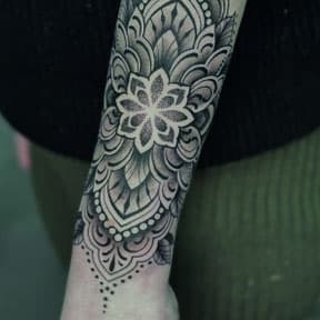 Grote ornamentale mandala tattoo op onderarm en pols met dotwork.