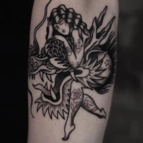 Blackwork tattoo van een vrouw die een draak omhelst, op de onderarm.