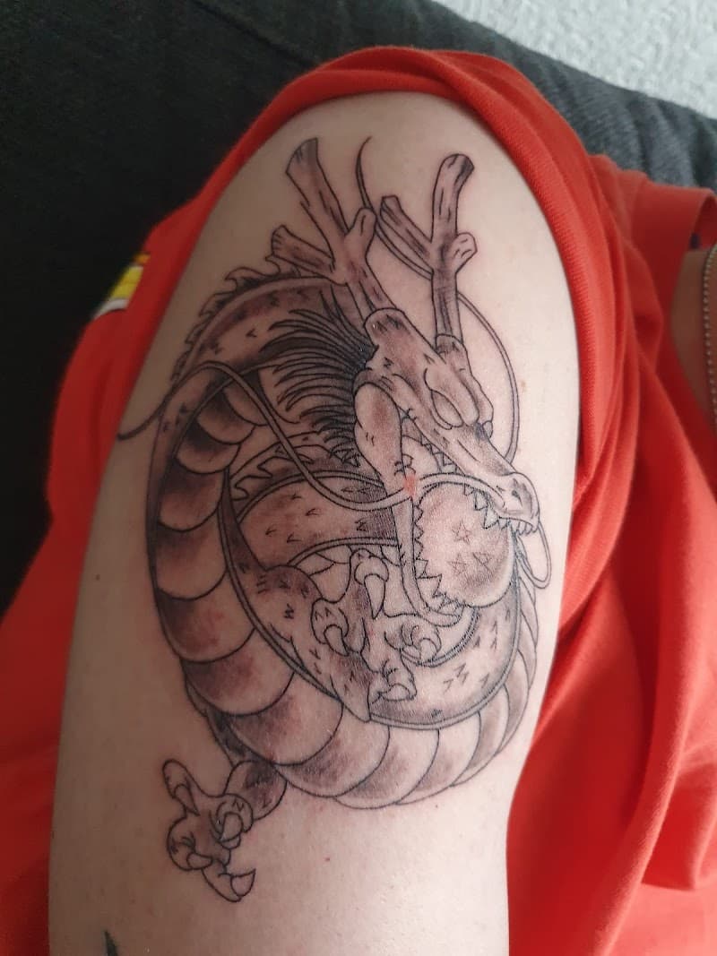 Blackwork tattoo van Shenron de draak uit Dragon Ball Z op de bovenarm.