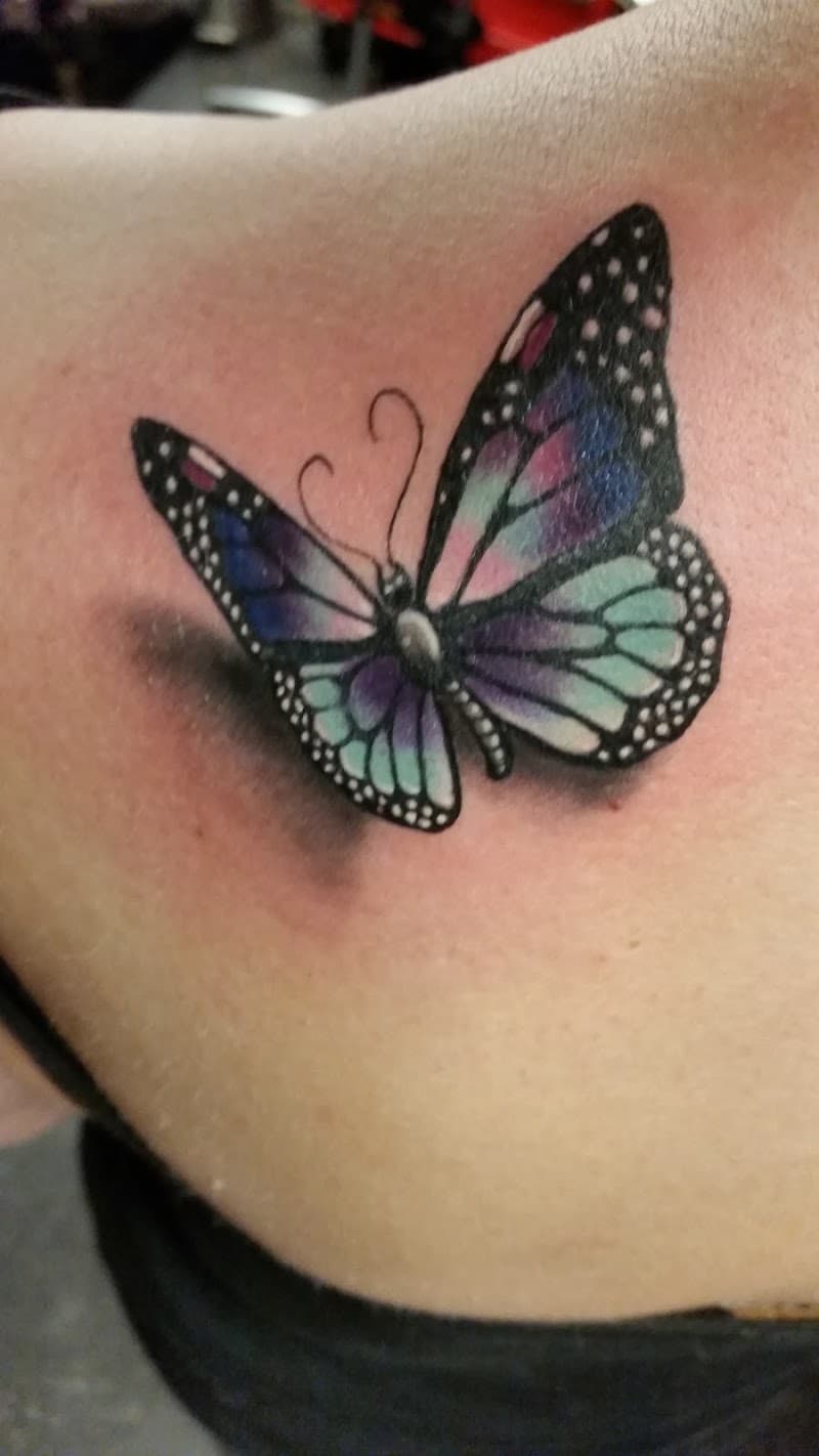 Realistische 3D vlinder tattoo op schouderblad.