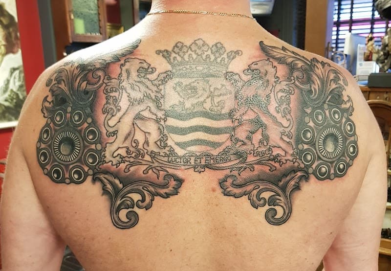 Grote rugtattoo van het wapen van Zeeland met leeuwen en de spreuk 'Luctor et Emergo'.