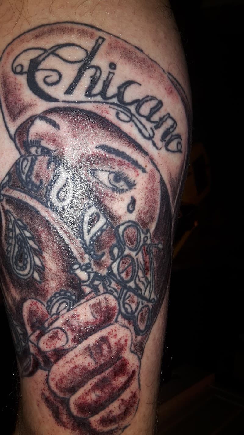 Chicano stijl tattoo van een vrouw met bandana en 'Chicano' tekst.