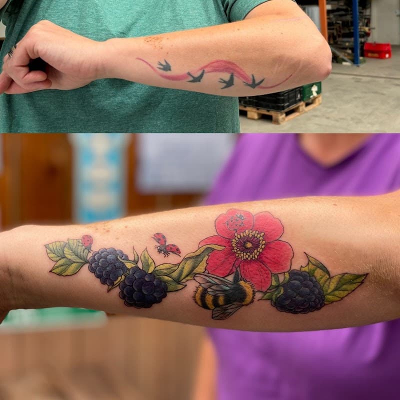 Kleurrijke tattoo van een bloem, bramen, hommel en lieveheersbeestjes op de onderarm.