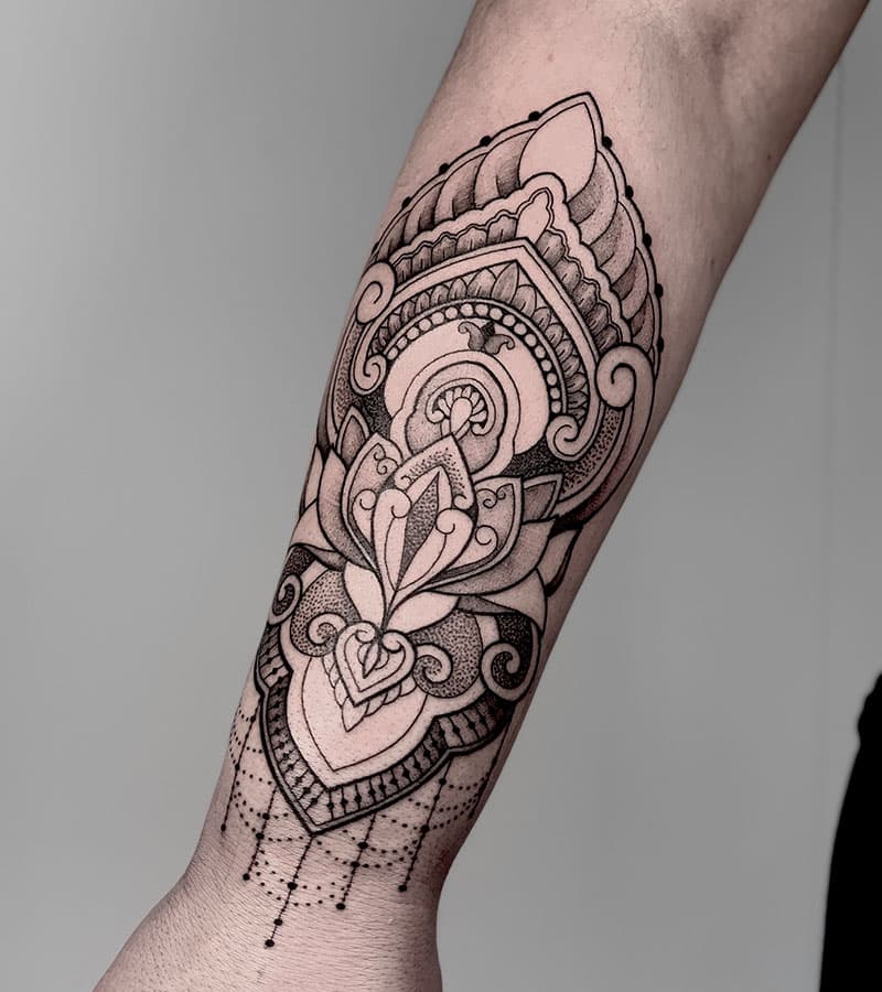 Gedetailleerde ornamental mandala tattoo op de onderarm.