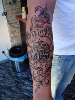 Zwart-wit half-sleeve met klok, tandwielen, naam 'Djingy' en datum.