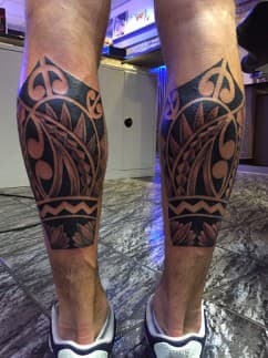 Symmetrische Polynesische tribal tattoos op beide kuiten.