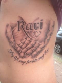 Handen met naam 'Ravi' en tekst 'My life, my pride, my boy' op ribben.