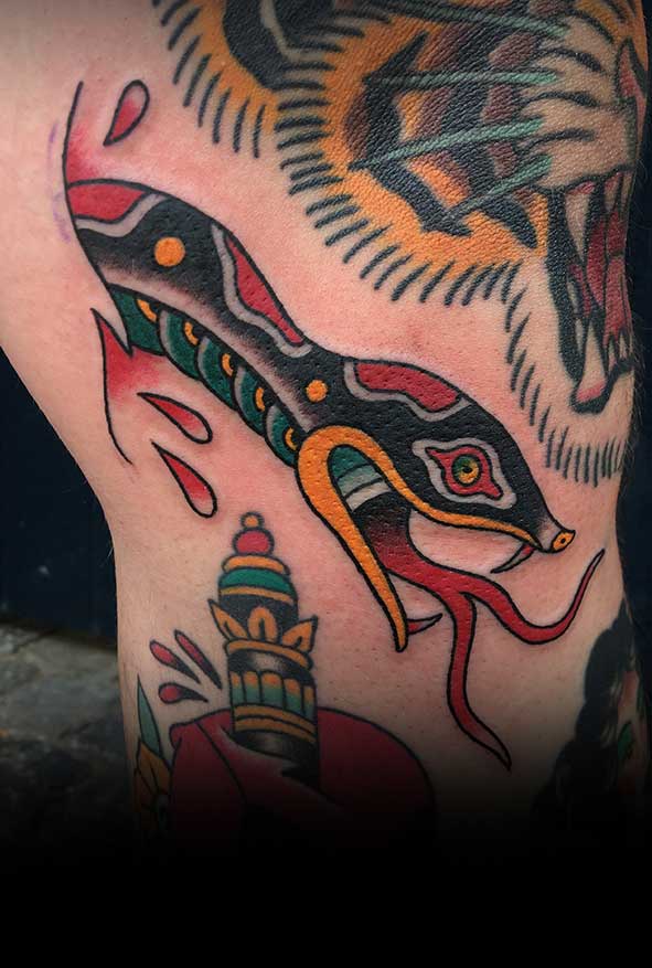 Traditionele slang, tijger en dolk tattoos op been.