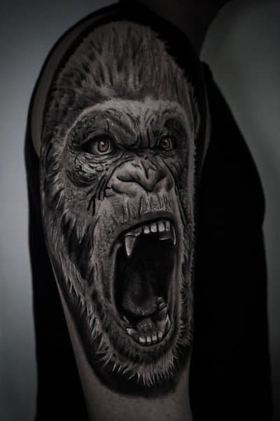 Realistische gorilla tattoo op bovenarm, brullend.