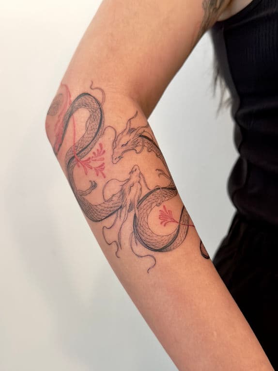 Fineline tattoo van twee draken met rode bloemen op de onderarm.