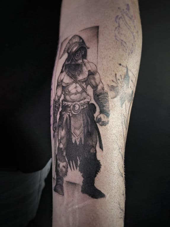 Gedetailleerde zwart-wit tattoo van een Romeinse gladiator op de onderarm.