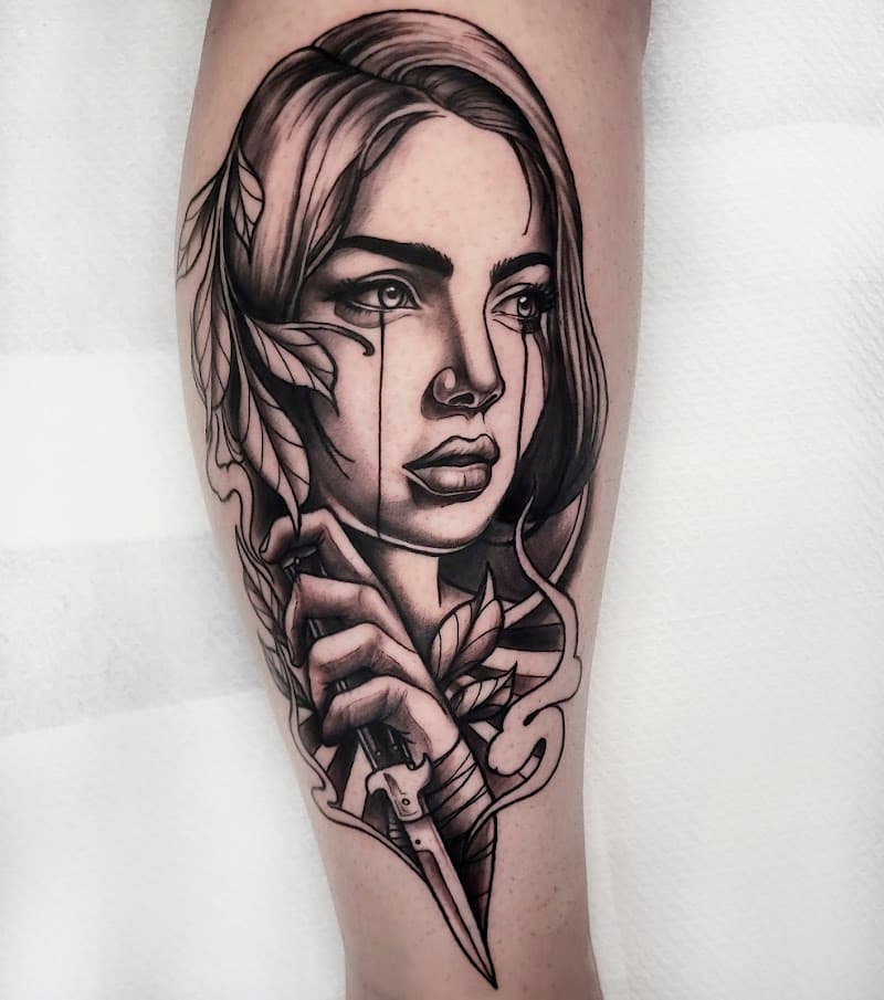 Zwart-wit tattoo van een huilende vrouw die een dolk vasthoudt, met bladeren.