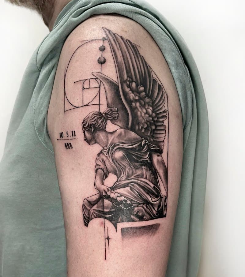 Realistische engel standbeeld met gulden snede en datum op bovenarm.