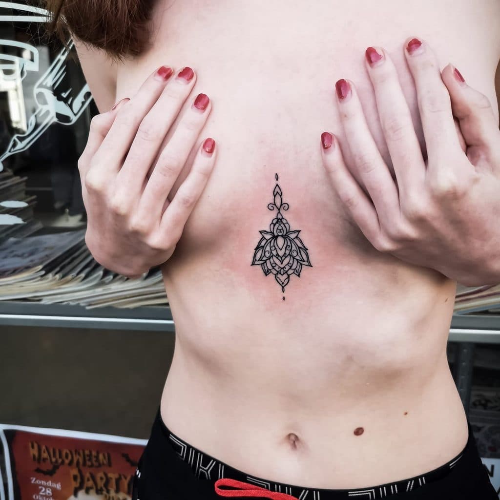 Elegante fineline mandala tattoo op het borstbeen.