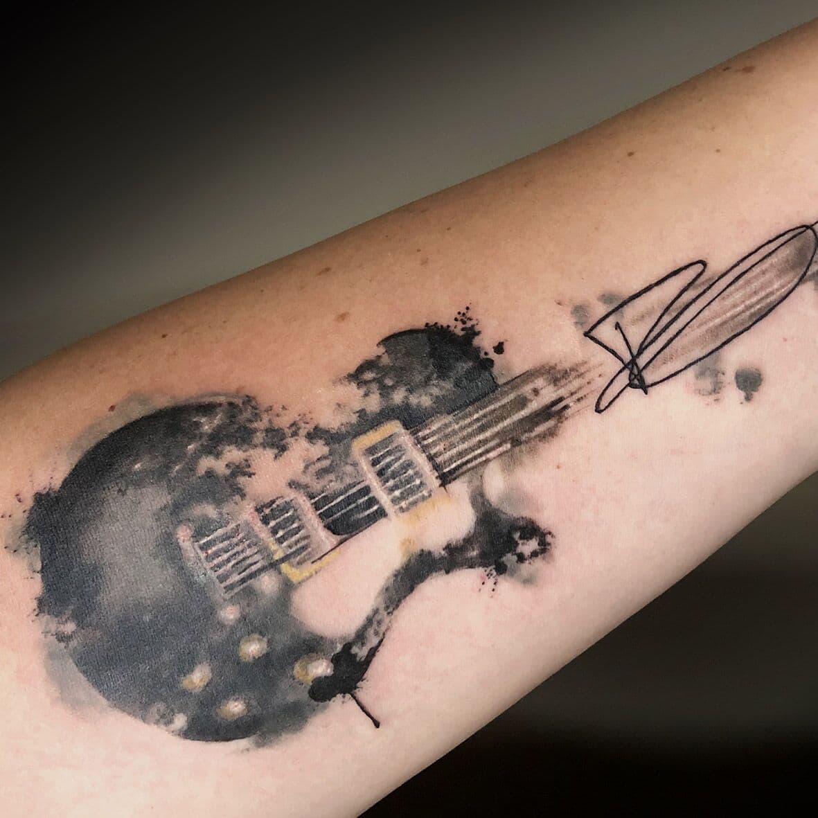 Watercolor elektrische gitaar met handtekening op onderarm.