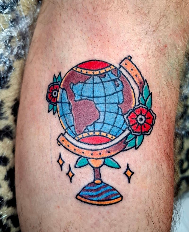 Old school globe tattoo met bloemen op onderbeen.