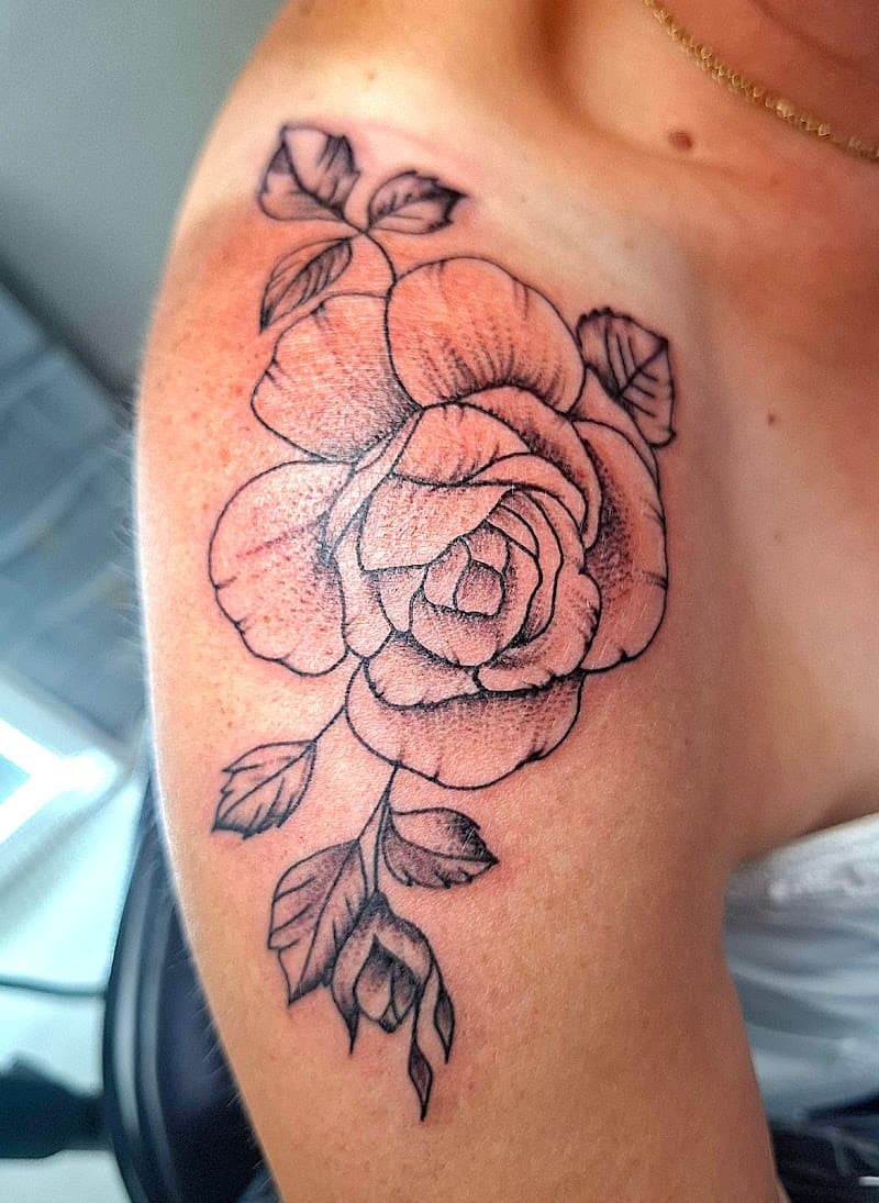 Fineline roos met bladeren op de schouder.