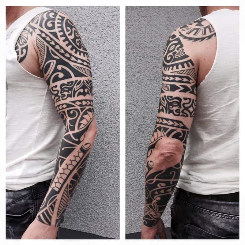 Zwart-witte Polynesische tribal sleeve tattoo op een mannenarm.