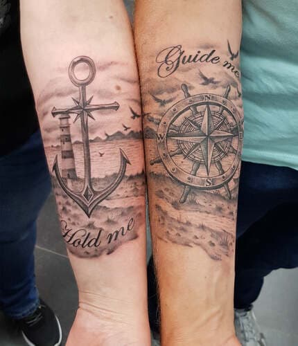 Bijpassende zwart-wit tattoos op onderarmen: anker met vuurtoren en kompas.