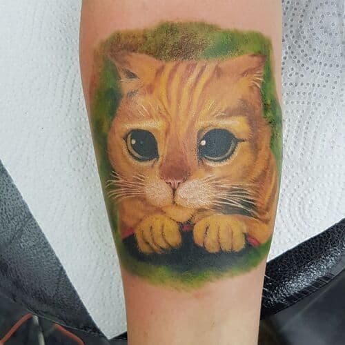 Realistische kleuren tattoo van de gelaarsde kat met grote ogen.