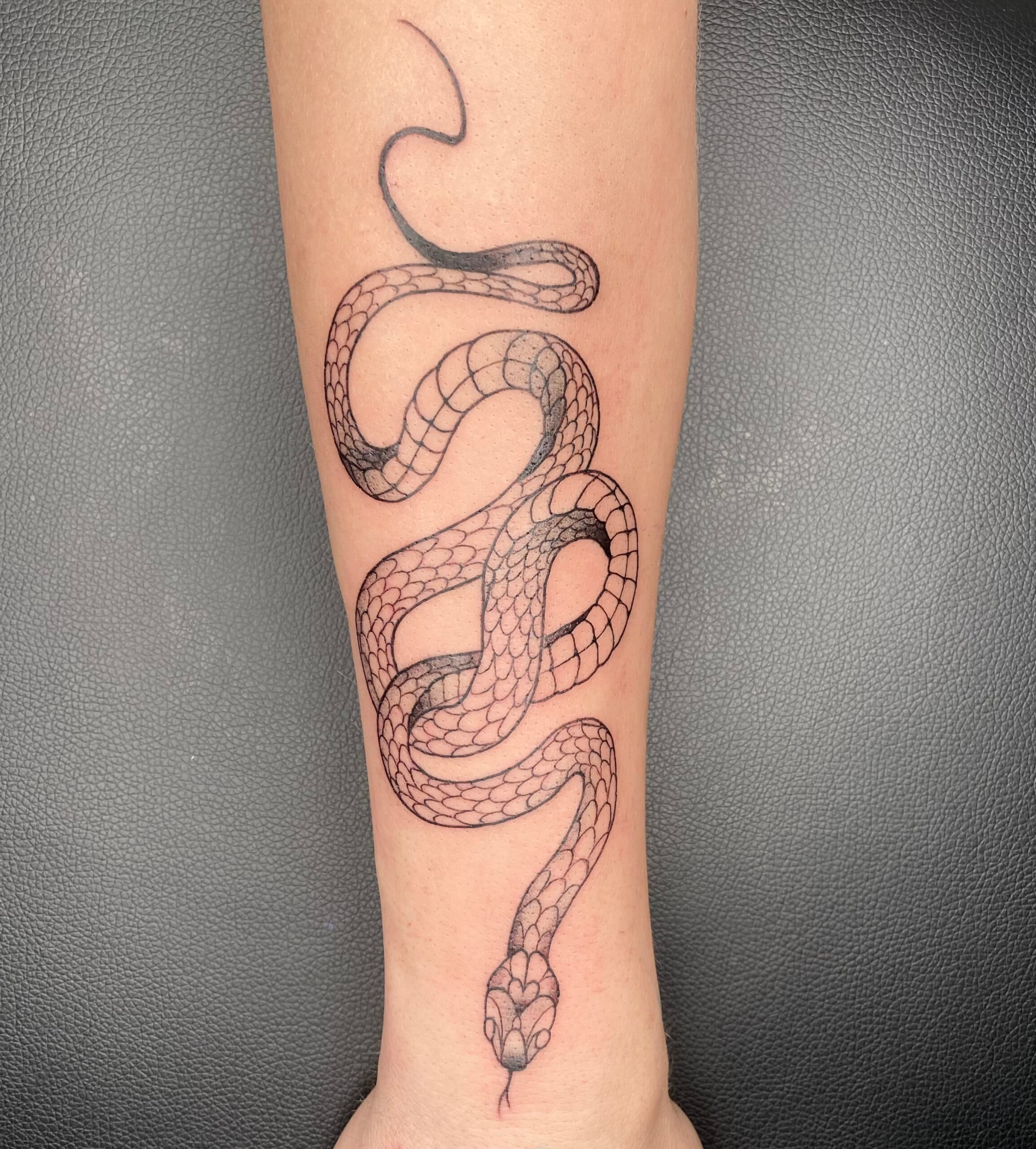 Fineline slang tattoo op onderarm.