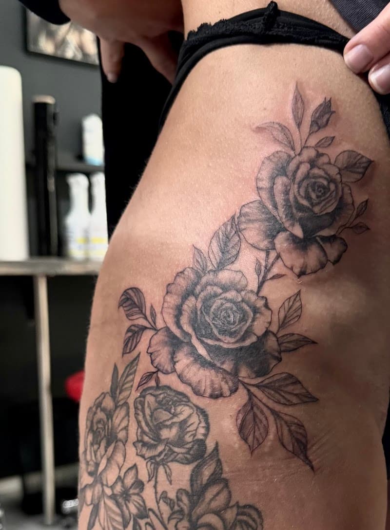 Zwart-wit rozen tattoo op de heup en bovenbeen.