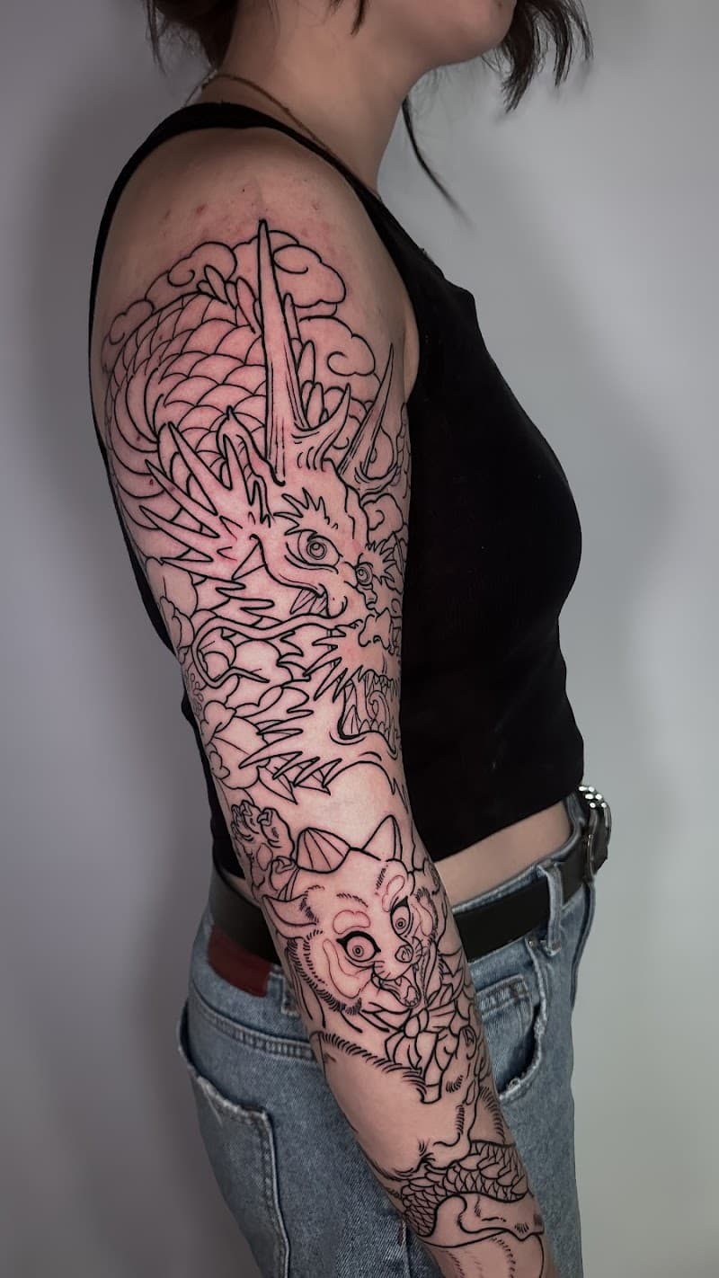 Grote Japanse draak en kat-wezen in lijnwerk op de arm.