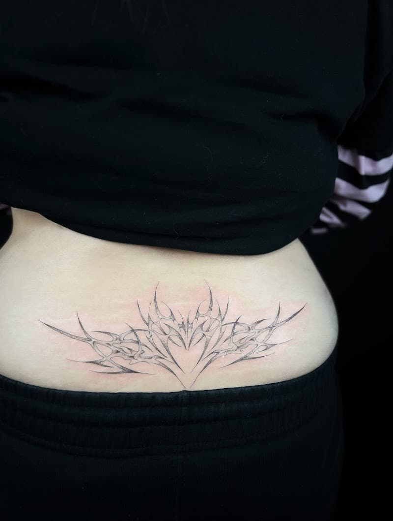 Abstracte tribal-stijl tattoo op de onderrug.