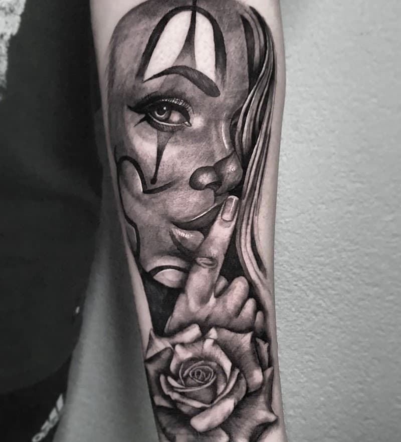 Zwart-wit tattoo van een clownvrouw die 'ssst' gebaart, met een roos eronder.