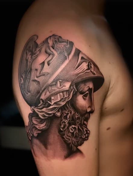 Realistische zwart-wit tattoo van een Griekse krijger met helm op de bovenarm.